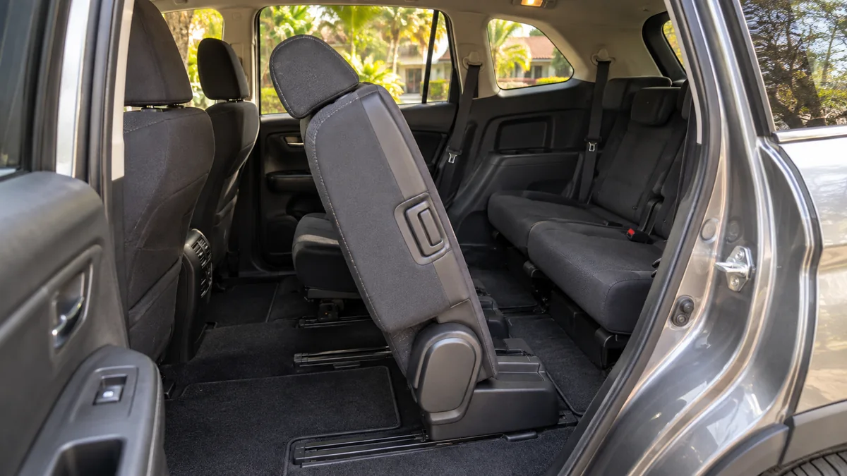 Second-row seat tilted forward beside the passage to the rear seats