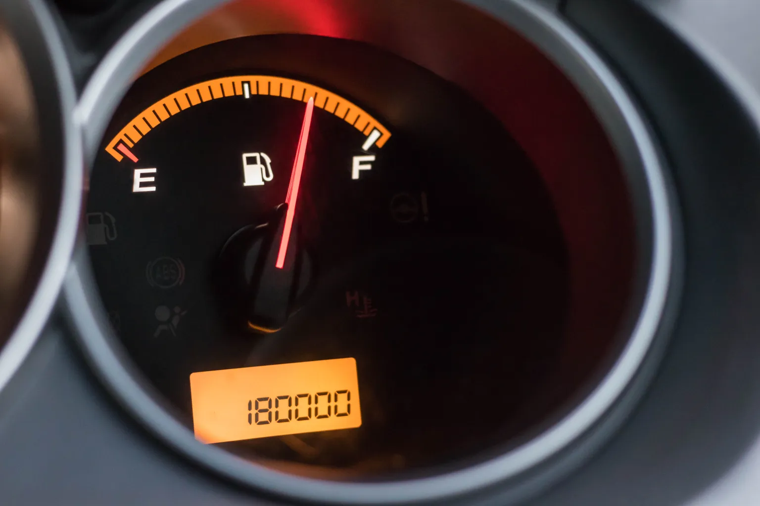 A dashboard fuel gauge and digital distance readout.