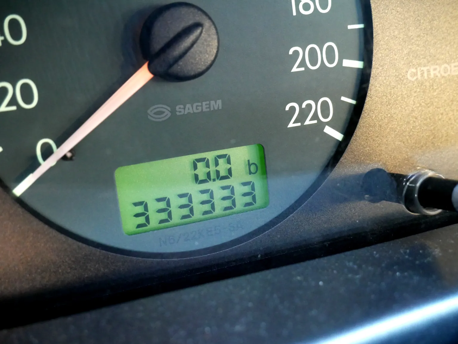 Electronic odometer showing a distance reading in a photographed car dashboard.